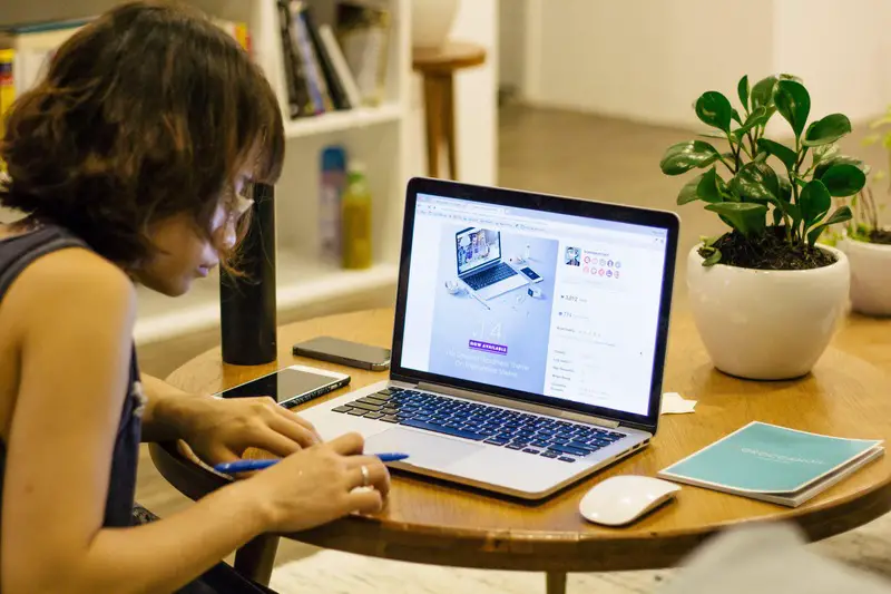 Woman studying on a laptop, focused and determined.